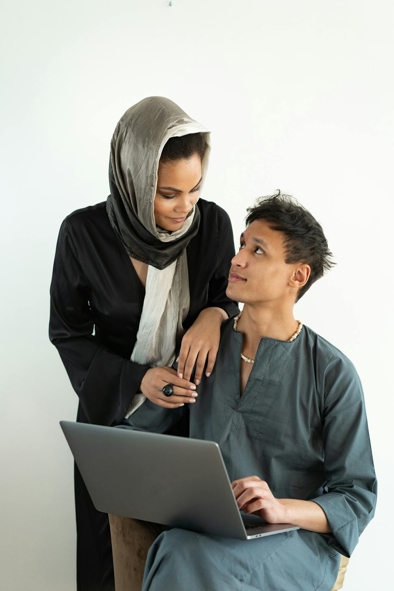 Young couple collaborating indoors with a laptop, depicting teamwork and modern technology.